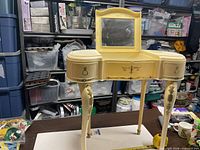 Full view of cream plastic Marx child's vanity table on table top