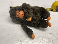 Full view of plush gorilla doll showing body and measuring tape for scale