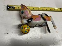 Right side view showing cat posture, ball, key and measuring tape