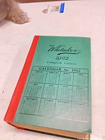 Front view showing green cover sheet on red cloth hardcover