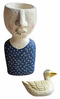 Front view of concrete bust planter and ceramic duck