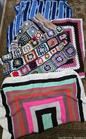Four crocheted afghans stacked showing overall designs