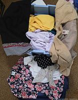 Assorted garments inside blue tote showing black skirt, yellow top, lavender blouse, beige blazer