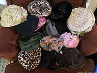 Twelve assorted vintage women’s hats arranged on chair