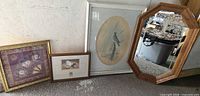 Group view of all four framed pieces: bird print, floral fan print, nursing still life, octagonal mirror