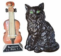 Front view of both items: violin-shaped decanter and black cat figurine