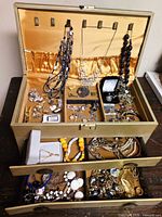 overall view of open jewelry box showing contents in trays and drawers