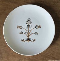 Top view of white ceramic platter with gold/black stylized tulip motif