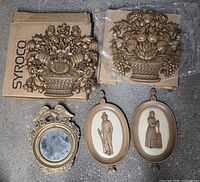 Overall lot showing two fruit basket plaques in original boxes, two oval colonial plaques, eagle mirror
