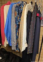 Group of blouses and skirts hanging on rack showing colours and patterns