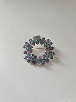 Front view of round Avon rhinestone brooch showing stone arrangement