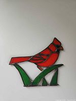 Front view of stained glass cardinal on grass