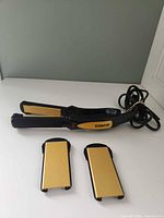 Straightener with two extra plates on white surface