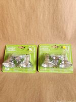 Front view of both sealed 3-packs showing bulb style and wattage