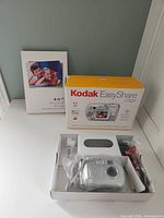 Camera, retail box, manual booklet and contents in tray