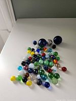 All 64 assorted glass marbles spread out on tabletop