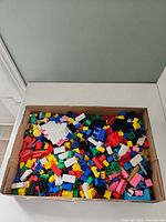 Full view of the box filled with colourful plastic building bricks