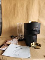 Front view of Nespresso Vertuo Pop+ coffee maker with accessories and manuals