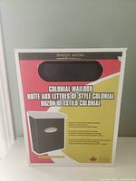 Front of retail box showing colonial mailbox image and bilingual labeling