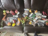 Full lot laid out on couch showing loose fruits, vegetables, sealed mini veggie bags and decorative stem