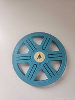Front view of blue plastic film reel showing five-spoke design and beige hub