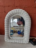 Front view of white wicker arched mirror