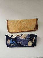 Front view of both glasses cases, Foster Grant floral and unbranded tan