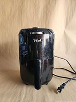 Front view of black T-fal air fryer with handle and power cord