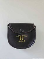 Front view of closed brown leather holster showing logo and snap