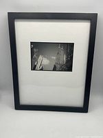 Full view of framed photograph showing black frame and white mat