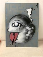 Front view of painting showing stylized grayscale face with pink tongue and drip details on gray-blue geometric background