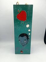 Front view showing apple, portrait, heart imagery on teal background