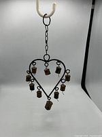 Full view of heart-shaped iron wind chime with nine bells