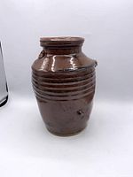 Full front view of brown glazed ribbed pottery vase