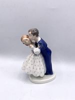 Front view of porcelain figurine showing boy kissing girl