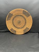 Front view of circular handwoven basket tray showing full geometric pattern