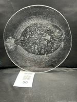 Full front view of clear glass plate with flounder motif