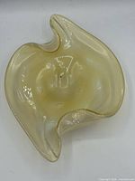 Top view showing freeform shape, pale yellow opaline color and internal bullicante bubbles