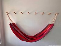 Hammock hung on wall showing full shape and rope loops