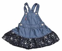 Full front view of denim jumper dress showing two-tone design and star ruffle hem