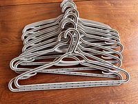 Stack of 15 gray plastic hangers showing overall design and quantity