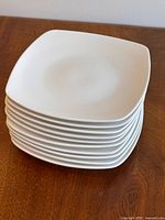 Stack of ten white square plates top view