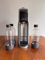 Front view of SodaStream Jet unit flanked by two carbonating bottles