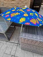 Umbrella open on patio furniture, showing canopy pattern