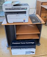 Printer on stand with keyboard and toner box visible