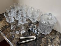 Group shot of all items: 12 stemware, ice bucket with lid, bar tool stand, tongs, glass pourer
