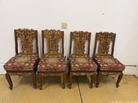 front view showing all four carved chairs with cushions
