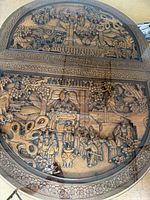 Full view of oval tabletop showing entire carved scene under glass