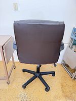 rear view of padded office chair beside folded table