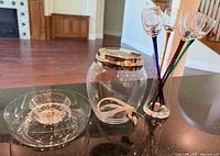 Beverage dispenser, five colored-stem glasses in holder, small plate with bowl component of chip-and-dip